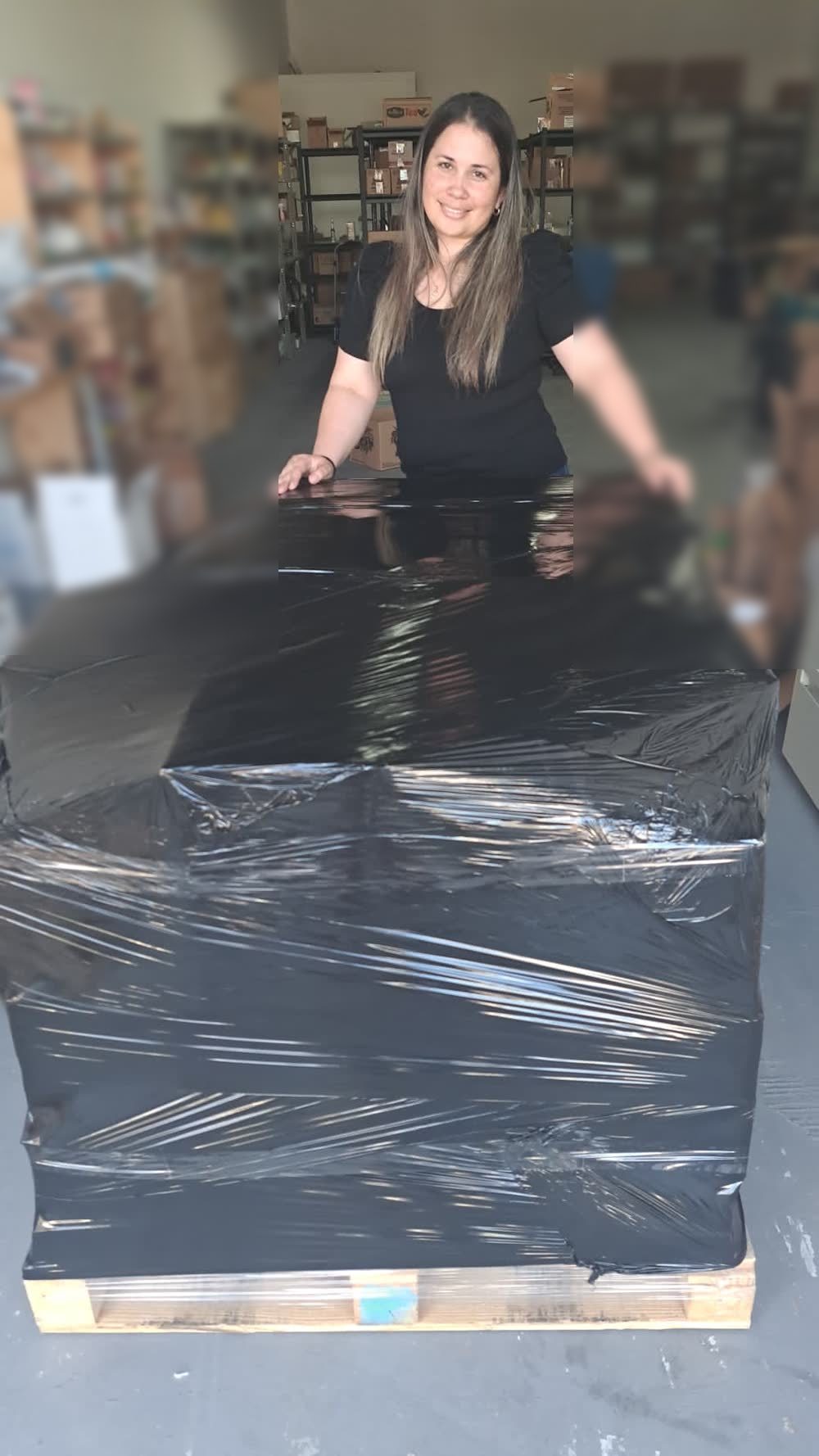 Mary Valdés junto a un palet de inventario preparado para enviar a Amazon